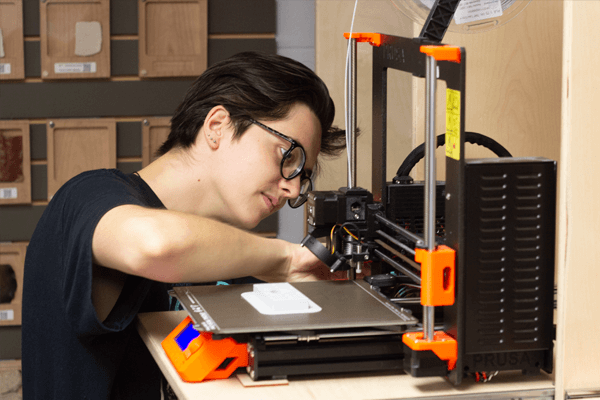 photo d'une membre du Fabbulle en train de régler l'imprimante 3D Prusa du Fablab.